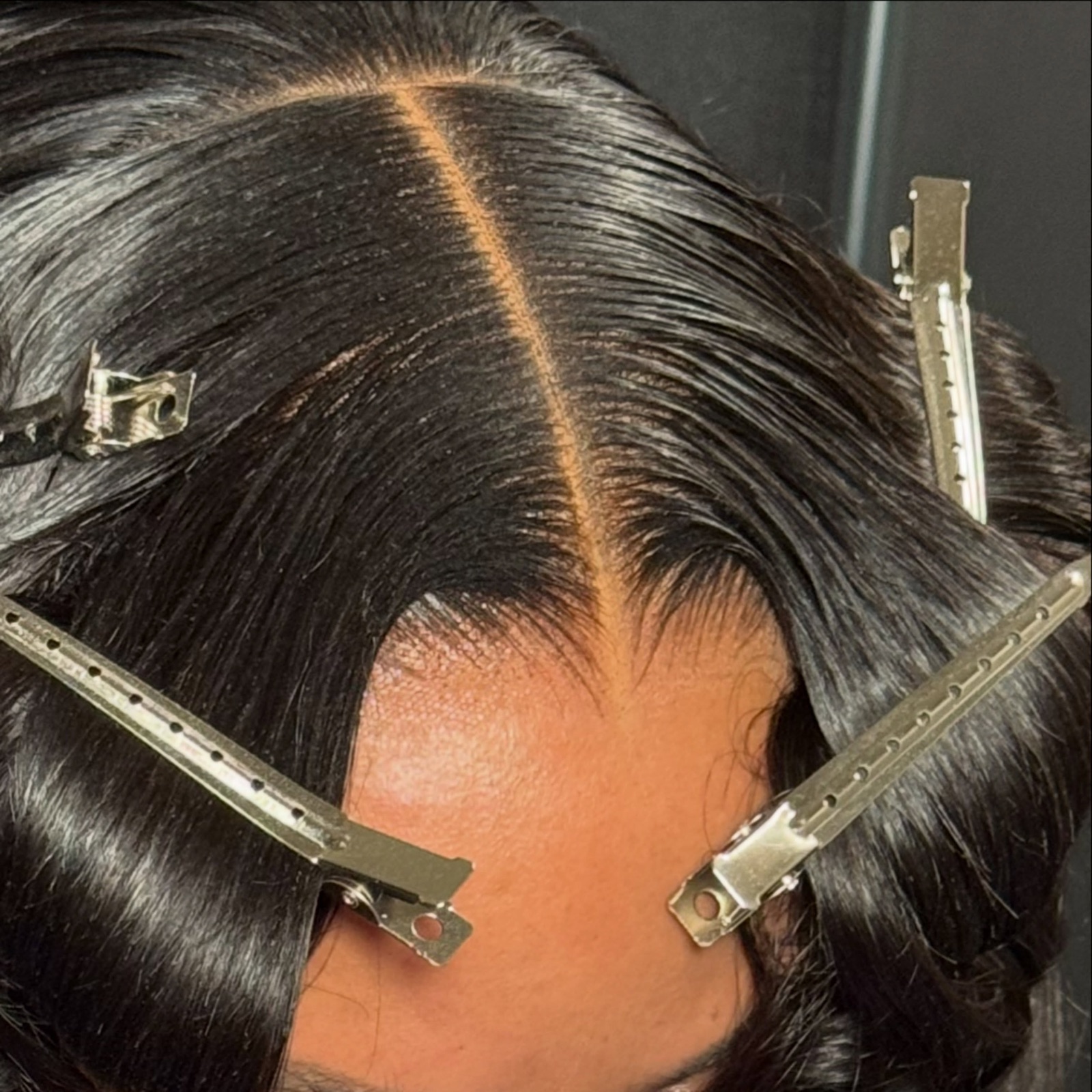 Close-up of a clean middle part sectioned with clips